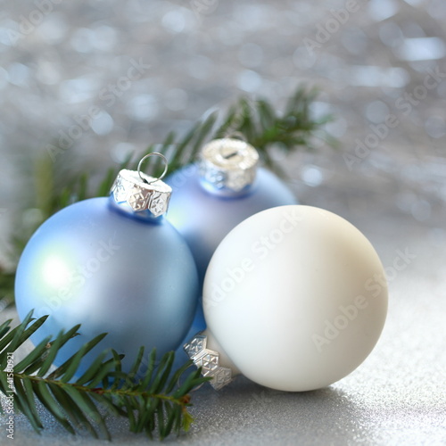 eisblaue Weihnachtskugeln mit Tannenzweig