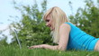 Detalii fotografie Woman lying in the grass with a laptop