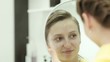 The girl after a hair-cutting looks at itself in a mirror