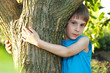 boy touch tree in forest - child care ecology