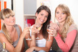 Three female friends drinking wine on sofa