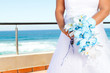 bride holding beautiful bouquet, background is sea view