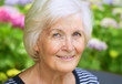 Porträt einer Seniorin im Garten