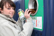 Woman putting glass in a recycling bin
