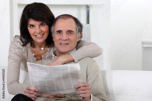 Photo: Mature couple looking at a newspaper Mature couple looking at a newspaper