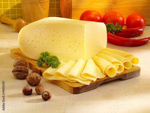 Photo: Ararangement with appetizing cheese on the kitchen table. Ararangement with appetizing cheese on the kitchen table.