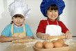 Dos niñas cocinando masa y pizza en una cocina.