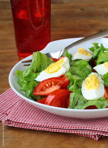 Photo: salad with eggs and fresh vegetables, on a plate salad with eggs and fresh vegetables, on a plate