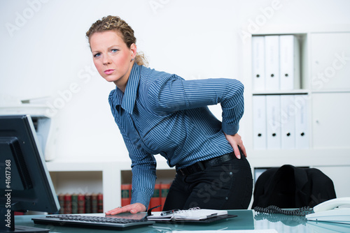 Photo: frau mit bandscheibenprobleme im büro frau mit bandscheibenprobleme im büro