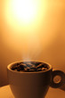 Dampfende Kaffeebohnen in Tasse Dampfende Kaffeebohnen in Tasse