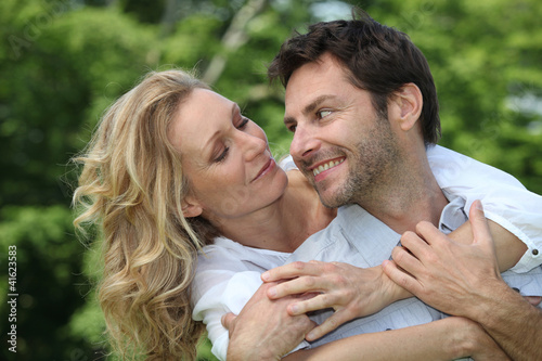 Photo: Blonde woman hugging man from behind Blonde woman hugging man from behind