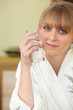 Woman drinking a glass of milk in her bathrobe