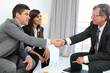 Business couple shaking hands with partner.