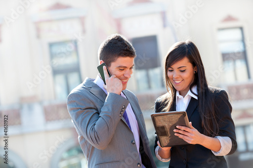 Photo: Business couple outdoors with tablet. Business couple outdoors with tablet.