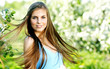beautiful woman wearing blue dress  over spring orchard