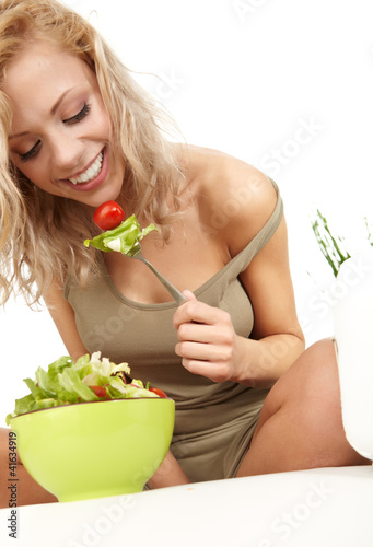Photo: Healthy lifestyle - smiling woman with vegetable salad on white Healthy lifestyle - smiling woman with vegetable salad on white