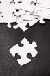 Blank white jigsaw pieces on leather background Blank white jigsaw pieces on leather background