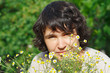 Young woman among the summer daisies outdoors
