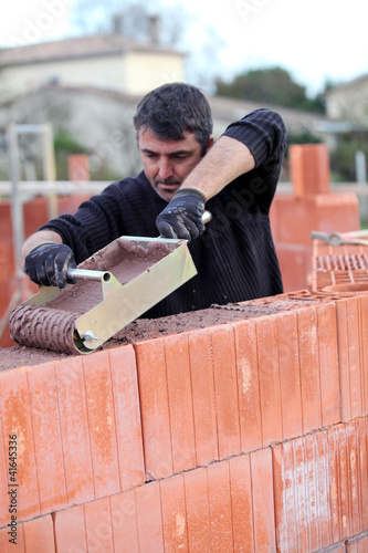 Photo: Builder laying blocks Builder laying blocks