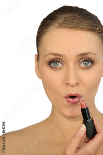 Photo: Woman applying lipstick Woman applying lipstick