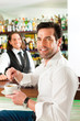 Barista mit Gast in seinem Cafe oder Coffeeshop