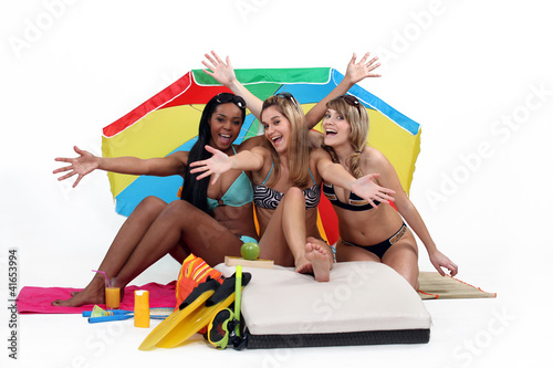 Foto: Friends sitting under a beach umbrella Friends sitting under a beach umbrella