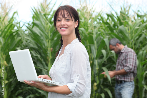 Photo: Woman using her laptop in a field of crops Woman using her laptop in a field of crops