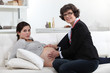 Mother touching pregnant daughter's belly