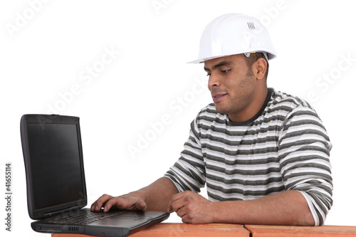 Photo: Builder sat using laptop Builder sat using laptop
