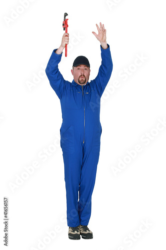 Foto: Man with wrench and raising arms in the air Man with wrench and raising arms in the air