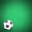 Football soccer ball by cork board on green grass