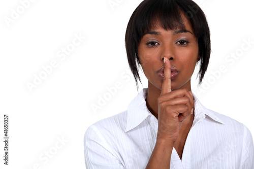 Foto: African American woman shushing. African American woman shushing.