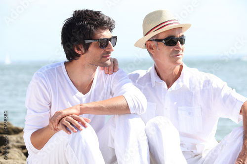 Foto: Grandfather with grandson sitting on a rock Grandfather with grandson sitting on a rock