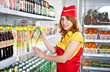 Photo: female the seller in the supermarket holding a box of juice female the seller in the supermarket holding a box of juice