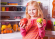 girl with fruits on background refrigerator