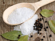 Salt in spoon on wooden background