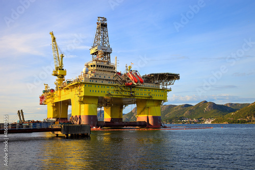 Photo: Oil rig near the mountains in Norway. Oil rig near the mountains in Norway.
