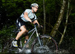 Mountainbiker durchquert Bachbett Mountainbiker durchquert Bachbett