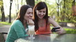 Video: Two female friends with mobile phone in outdoors restaurant Two female friends with mobile phone in outdoors restaurant