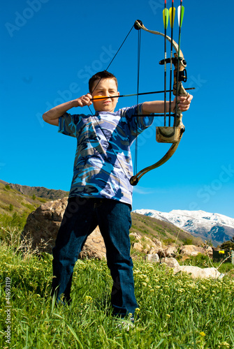 Photo: A young boy shooting archery A young boy shooting archery