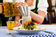 Leute in Bayerischer Tracht essen in Restaurant