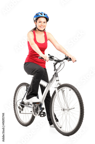 Photo: Female biker with helmet posing next to a bike Female biker with helmet posing next to a bike