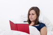 Woman reading a book in bed