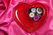 Heart shape plate with buttons on rosy wave background