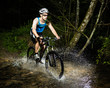 Mountainbiker durchquert Bachbett Mountainbiker durchquert Bachbett