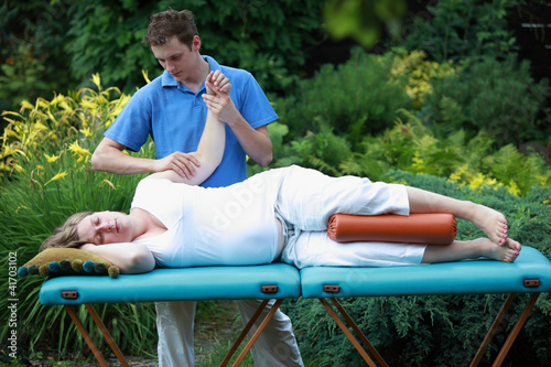 Foto: Physical therapist massaging pregnant woman's arm Physical therapist massaging pregnant woman's arm