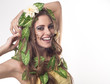 Beautiful young woman with flowers, leaves in her hair and origi Beautiful young woman with flowers, leaves in her hair and origi
