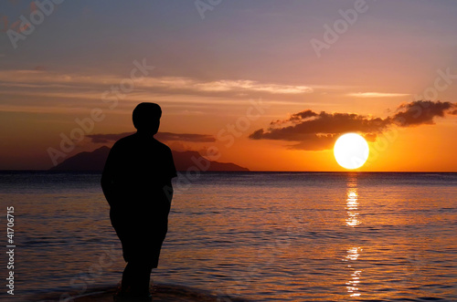 Photo: Lone on sunset . Man on paradise sunset beach. Lone on sunset . Man on paradise sunset beach.