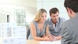 Couple in real-etate agency talking to salesman