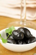 Pickle black olives in a bowl on a wooden table